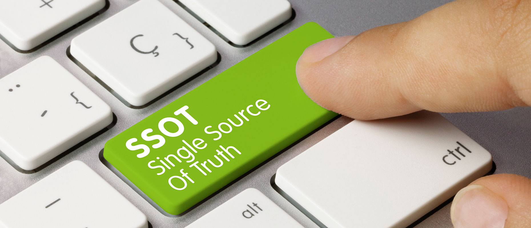 Finger tippt auf Taste am Laptop mit der Aufschrift Single Source of Truth